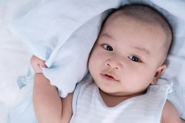 Bebê feliz deitado em uma cama — Fotografia de Stock