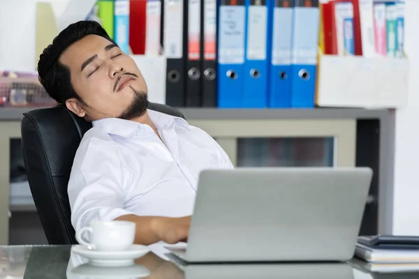Uomo d'affari che dorme sulla scrivania tra l'utilizzo di computer portatile compu — Foto Stock