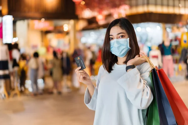 Νεαρή Γυναίκα Που Φοράει Ιατρική Μάσκα Και Κατέχει Πιστωτική Κάρτα — Φωτογραφία Αρχείου