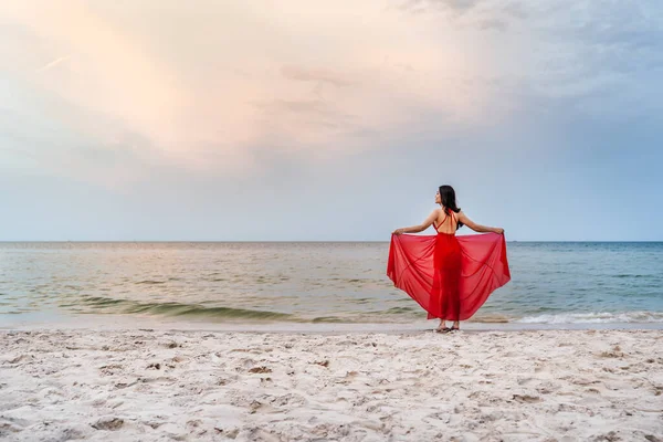 Ung Kvinna Med Armar Utspridda Röd Klänning Havet Stranden Med — Stockfoto