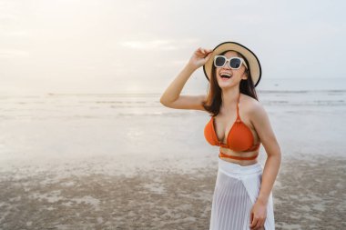 Bikinili neşeli kadın deniz sahilinde eğleniyor.