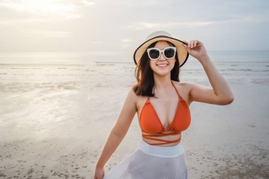 Bikinili neşeli kadın deniz sahilinde eğleniyor.