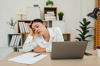 Evde dizüstü bilgisayarla çalışan sıkıcı genç bir kadın.