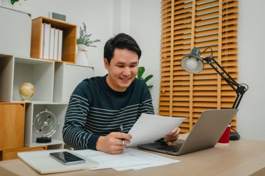 Mutlu genç adam evrak ya da evrak okuyor. Merkez büroda çalışıyorum.