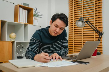 Mutlu bir adam ofis bilgisayarında belge ya da evrak yazıyor.