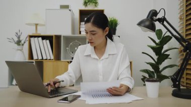 young woman reading document or paperwork. working at home office
