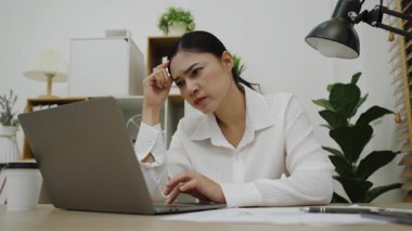 İş yerinde dizüstü bilgisayarla çalışırken genç bayanın baş ağrısı