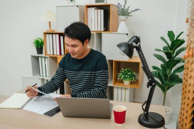 Mutlu genç adam evrak ya da evrak okuyor. Merkez büroda çalışıyorum.