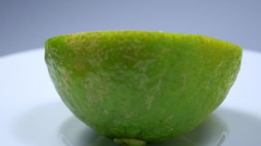 Taze yeşil limon dilimi yavaşça ayrıntıları ile stüdyoda döndürme.