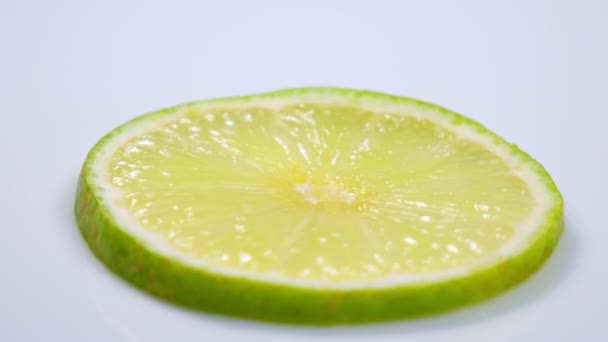 Fatia de limão verde fresco está girando lentamente no estúdio com os detalhes . — Vídeo de Stock