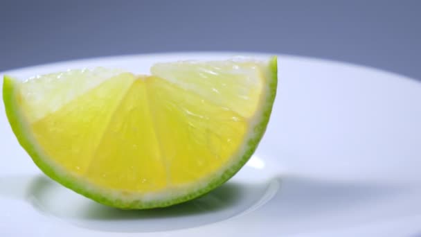 Fresh green lemon slice is slowly rotating in the studio with the details. — Stock Video