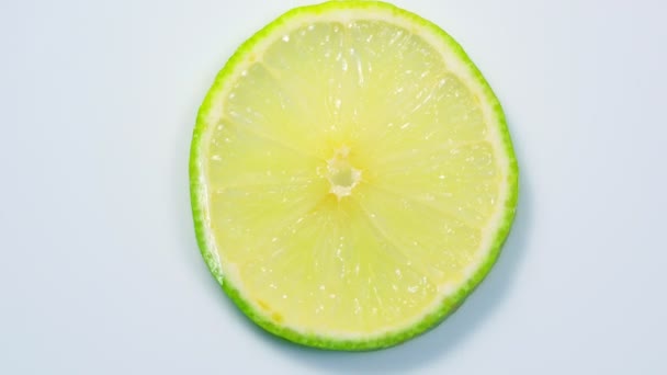新鮮な緑のレモン スライスの詳細とスタジオでゆっくり回転します。. — ストック動画