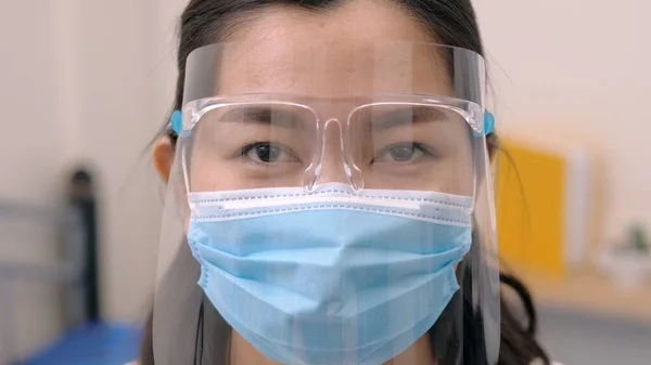 正面から顔の周りをマスクで覆ったアジアの若い女性の肖像画は 彼女の眼鏡や目を新しい正常な状態に準備を保護するために 彼女の顔の周りに丸みを帯びています コロナウイルスのパンデミック — ストック写真