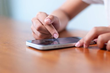 Modern dijital yaşam tarzı ve bağlantısını gösteren akıllı bir telefonla etkileşime giren bir kişinin yakın plan fotoğrafı..