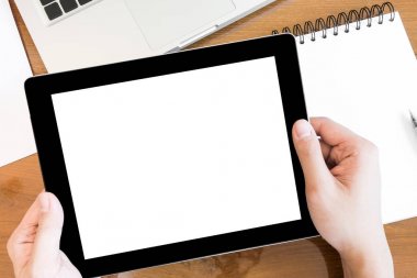 Bir adam beyaz boş ekran, üst görünümü ile bir tablet tutuyor.