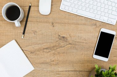 Bilgisayar araçları ve ofis malzemeleri ile ahşap ofis masasıüst görünümü. Düz yatıyordu.