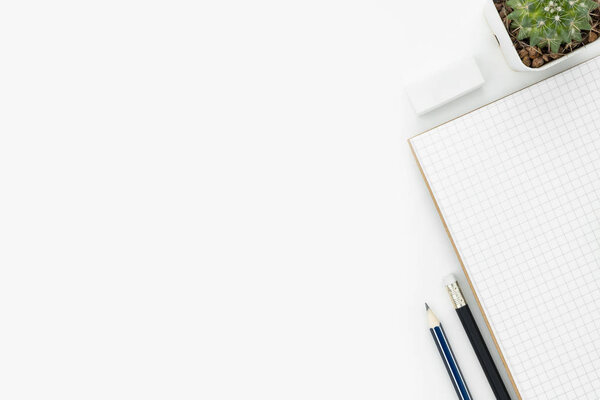 Белый студенческий стол с блокнотом, карандашами и ластиком. Вид сверху с копировальным пространством, плоская кладка
.