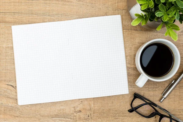 Tom anteckningsbok sida ovanpå Wood Office Desk Table. Övre vy med kopierings utrymme, Flat Lay. — Stockfoto