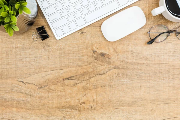 Mesa de escritorio de madera con aparatos de ordenador y suministros. Vista superior con espacio de copia, plano . — Foto de Stock