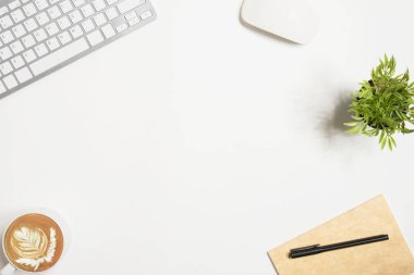 Üzerinde bir sürü şey olan beyaz ofis masası. Kopyalama alanı olan üst görünüm, düz yatay.