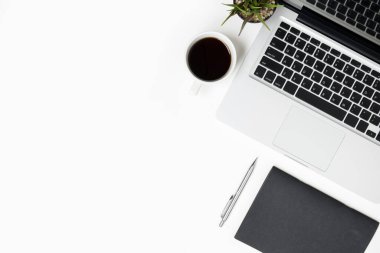 Laptop ve malzemelerle dolu beyaz ofis masası. Kopyalama alanı olan üst görünüm, düz yatay.