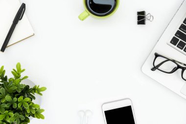 Üzerinde bir sürü şey olan beyaz, modern ofis masası. Kopyalama alanı olan üst görünüm, düz yatay.