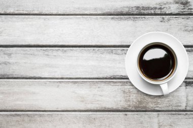 Bir fincan kahve ahşap masanın üstünde. Kopyalama alanı olan üst görünüm, düz yatay.