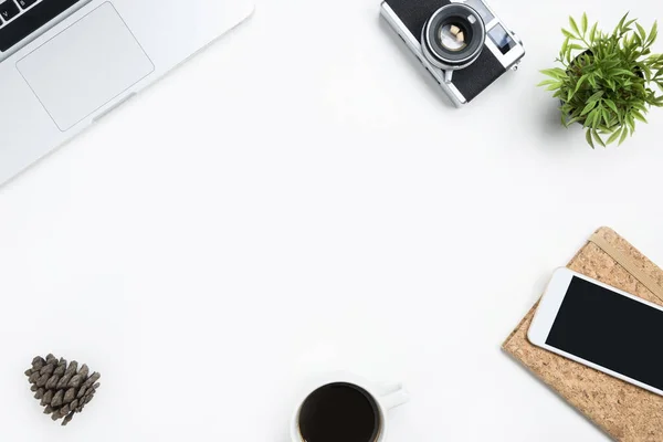 White photographer desk table with film camera, laptop and supplies. Top view with copy space, flat lay.