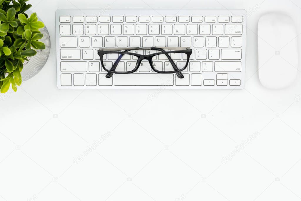 White hipster desk table with computer keyboard and mouse. Top view with copy space, flat lay.