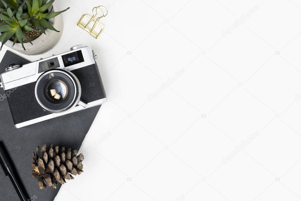 White photographer desk table with film camera and office supplies. Top view with copy space, flat lay.