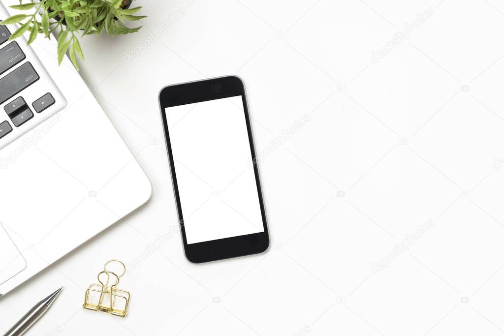 Smartphone with blank screen is on top of white table. Top view with copy space, flat lay.