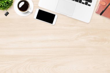 Akıllı telefon, dizüstü bilgisayar ve malzemelerle dolu ahşap ofis masası. Üst manzara, düz uzanma.