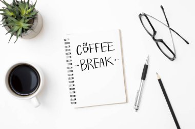 Üzerinde kahve kırılma metni olan defter sayfası. Üst manzara, düz uzanma.