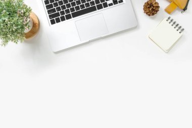 Laptop ve malzemelerle dolu modern beyaz ofis masası. Kopyalama alanı olan üst görünüm, düz yatay.