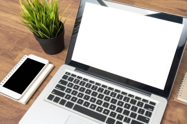 Dizüstü bilgisayar ve akıllı telefonu ahşap ofis masasının üstüne yerleştir.