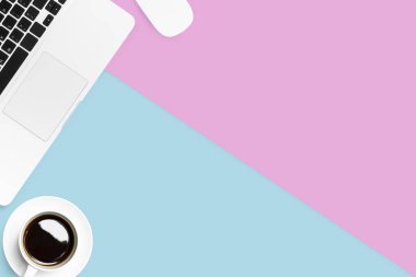 Laptop, kahve ve beyaz fareli Pastel pembe ve mavi ofis masası. Kopyalama alanı olan üst görünüm, düz yatay.
