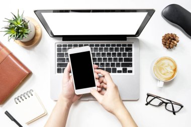 Bilgisayarının üzerinde akıllı telefon kullanan adamın ekranı boş..