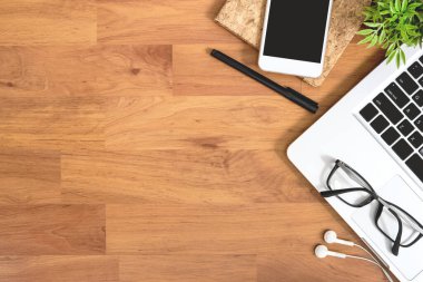 Ahşap ofis masasında bilgisayar gereçleri ve malzemeler var. Üst manzara, düz uzanma.