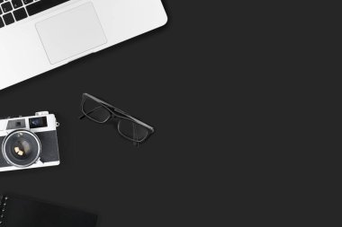 Kamera ve malzemelerle dolu siyah fotoğraf ofisi masası. Kopyalama alanı olan üst görünüm, düz yatay.