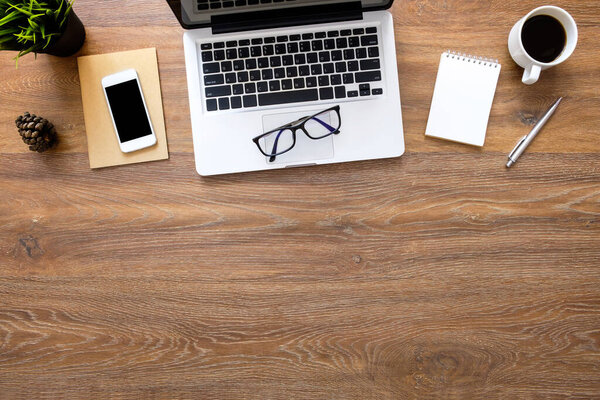 Стол стола из дерева с ноутбуком, смартфоном, чашкой кофе и принадлежностями. Вид сверху с копировальным пространством, плоская кладка.