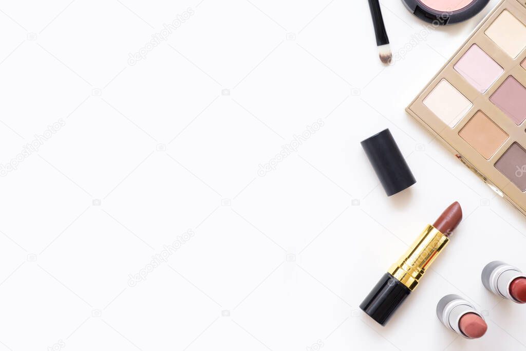 Top view of female table with makeup including lipsticks, eye palette, foundation, brushes and others. Flat lay, image.