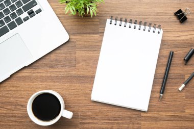 Kalemli boş defter ahşap ofis masasının üstünde. Üst manzara, düz uzanma.