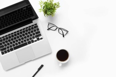 Laptop bilgisayarı, kahve ve diğer ofis malzemeleriyle dolu beyaz ofis masası. Kopyalama alanı olan üst görünüm, düz yatay.