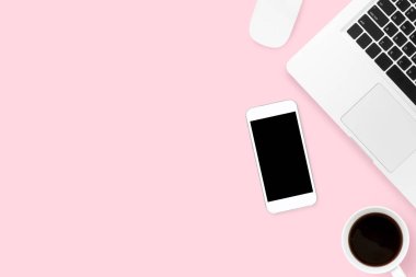 Akıllı telefon, laptop ve suppli pembe pastel ofis masası.