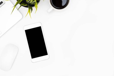 Beyaz ofis masasının üstünde boş ekranlı akıllı telefon var!