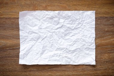 Boş katlanmış a4 kağıdı ahşap masa masasının üstünde. Üst manzara, düz uzanma.