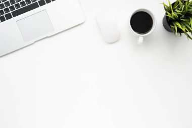 Laptop, kahve ve malzemelerle dolu beyaz ofis masası. Kopyalama alanı olan üst görünüm, düz yatay.
