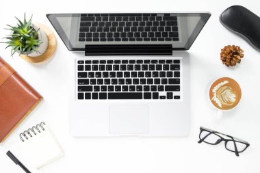 Laptop ve malzemelerle dolu modern beyaz ofis masası. Üst yaşam