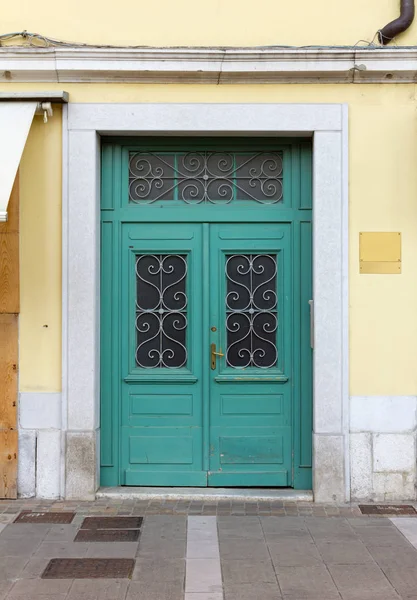 Bir tarihi kentsel inşaat sarı cephesinde ahşap turkuaz kapı