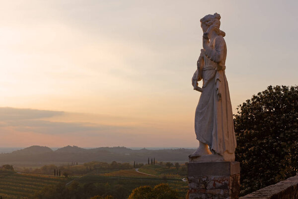 Sunset view of one of the neoclassic female marble statue on the terrace of Rosazzo abbey in the Friuli region, Italy